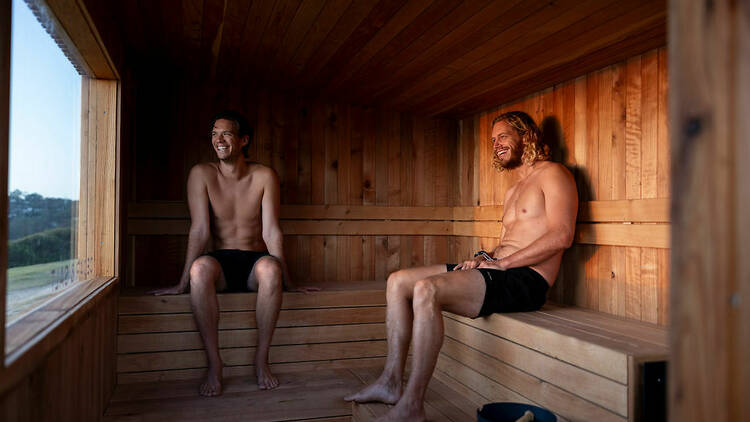 Two men relaxing in a sauna after a workout