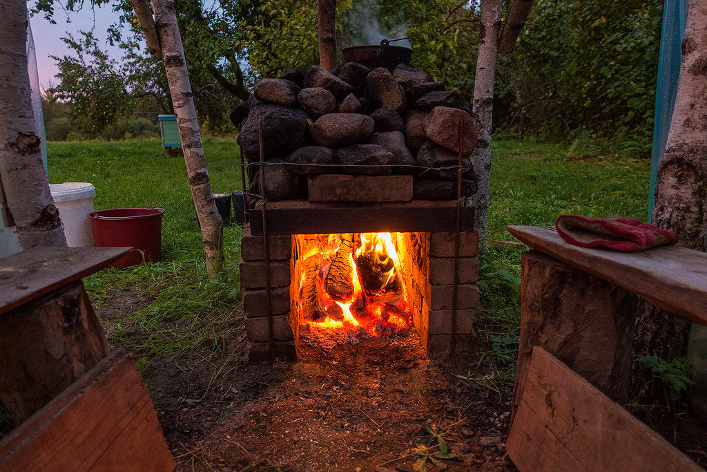 Outdoor wood-fired sauna stove at dusk, sauna traditions around the world