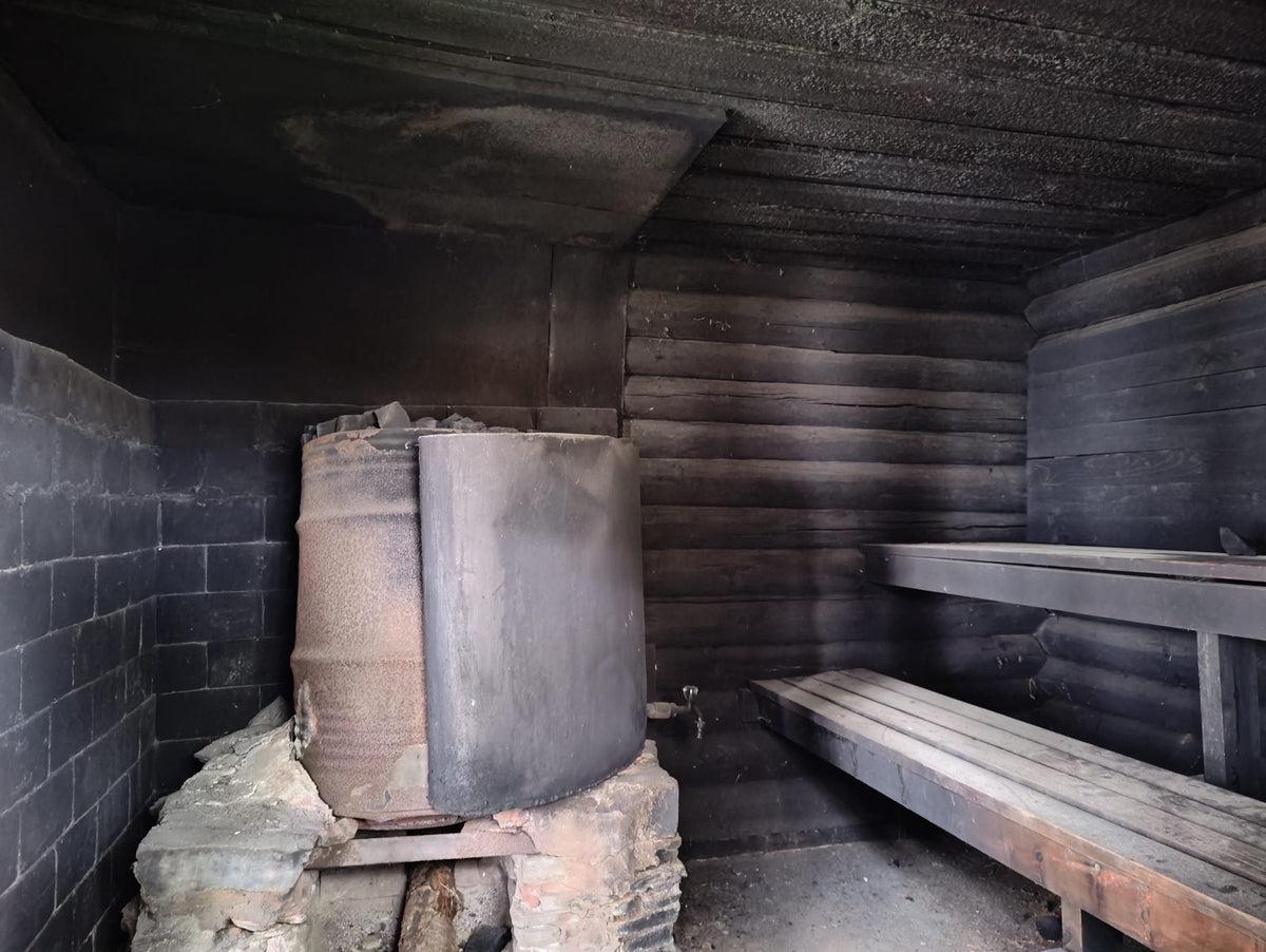 Traditional smoke sauna interior with stone stove, the ancient sauna ritual
