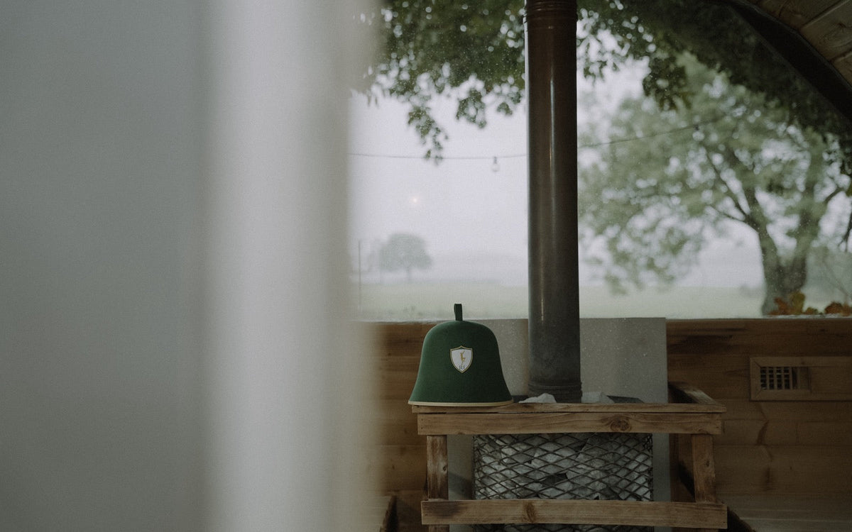 Rí Sauna Crown resting beside the stove in a wood-fired sauna