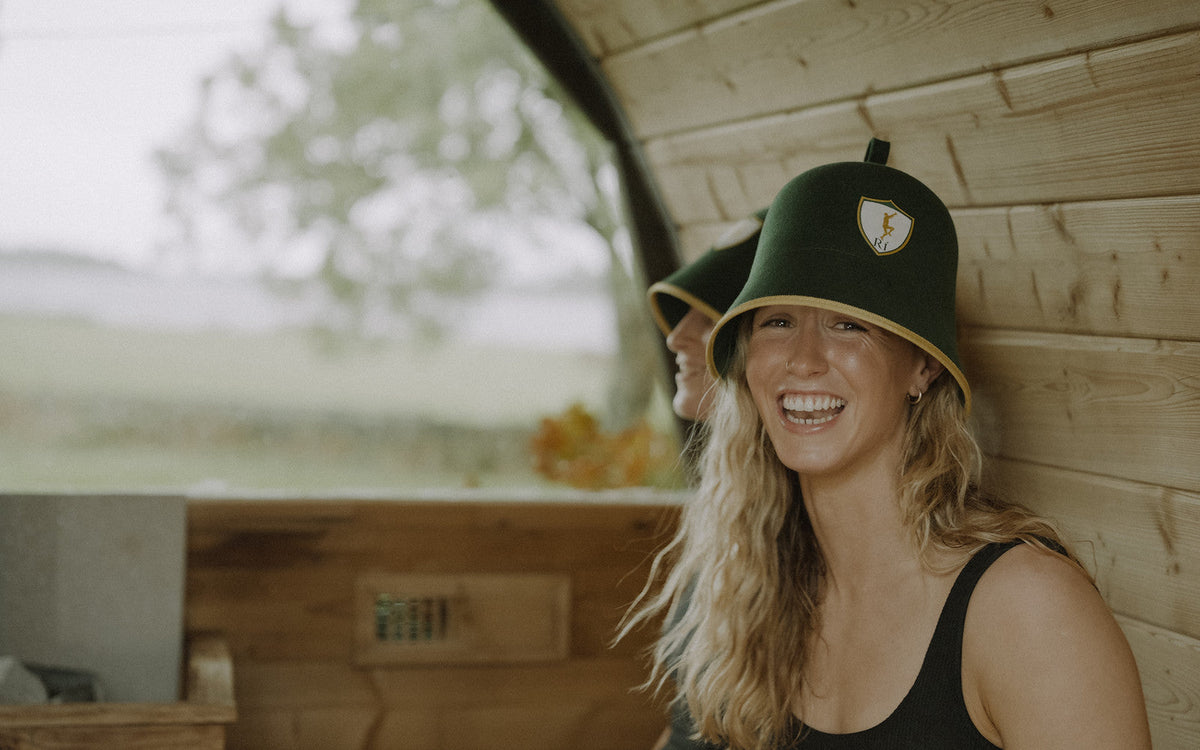 Athlete smiling in the sauna wearing the Rí Sauna Crown, why a sauna hat changes the session